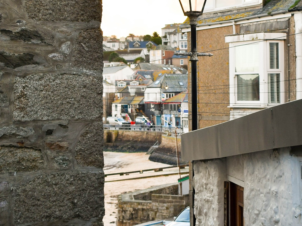 A Cornish harbour view through a stone arch