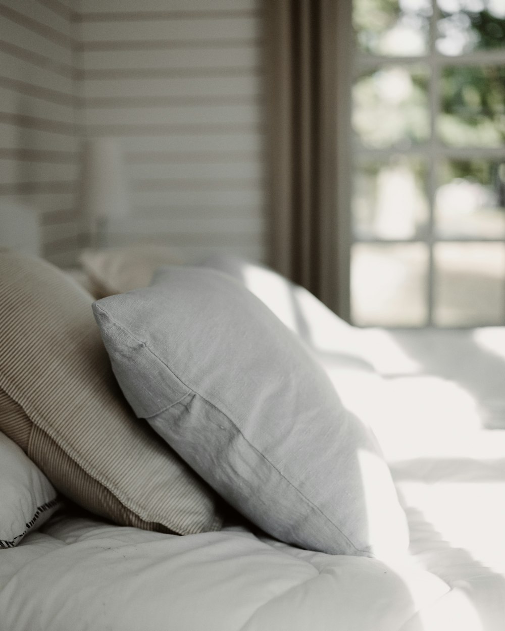 Linen pillows catching the light through the Garden Room blinds